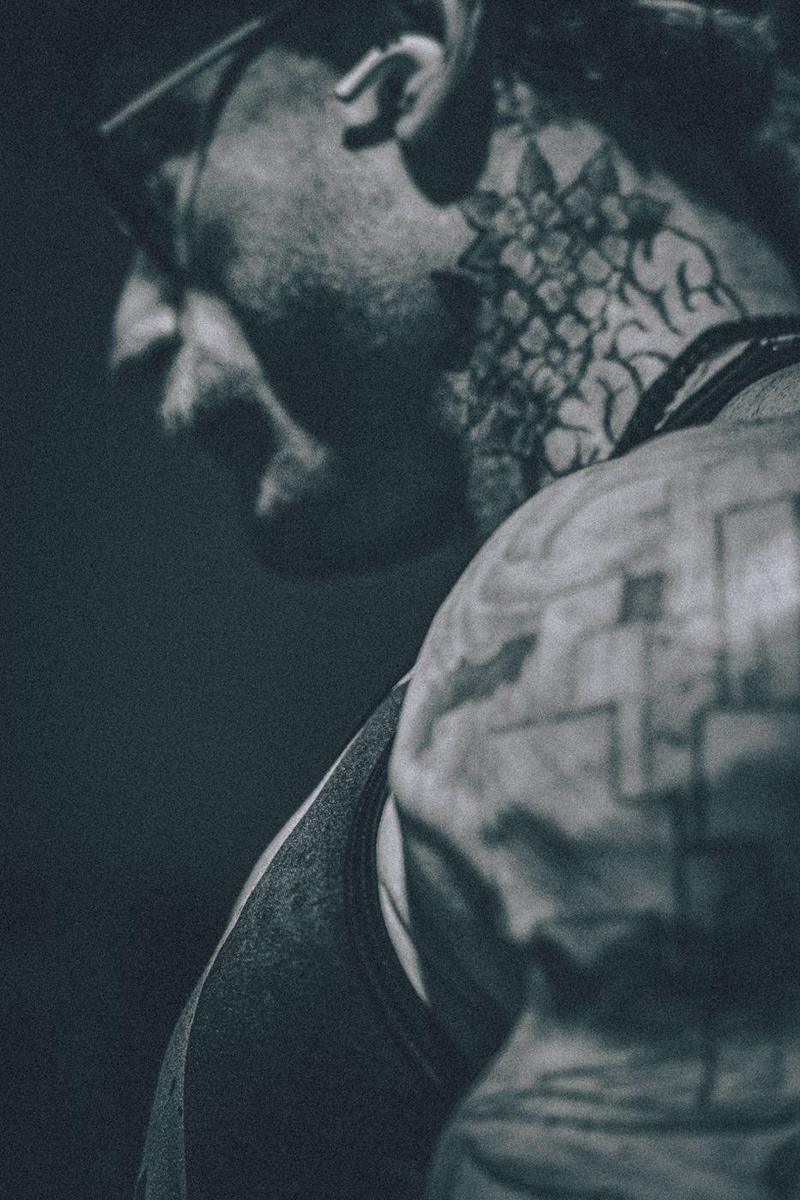 Monochrome close-up of a neck tattoo and capped shoulder