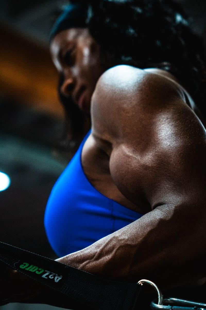 Female athlete on a cable machine, shoulder and arm in focus